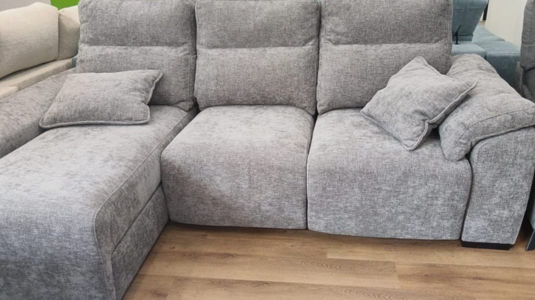 Sofá gris con chaise longue y cojines en Vigo